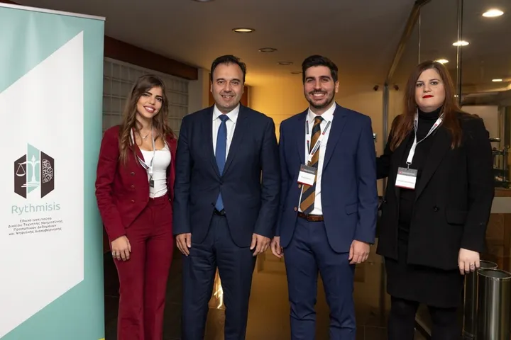 Μέλη του Ινστιτούτου Rythmisis σε εκδήλωση, μπροστά από το banner του ινστιτούτου
